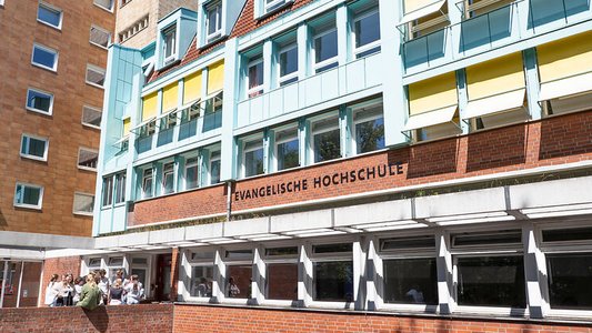 Studierende stehen vor der Evangelischen Hochschule für Soziale Arbeit und Diakonie Hamburg.